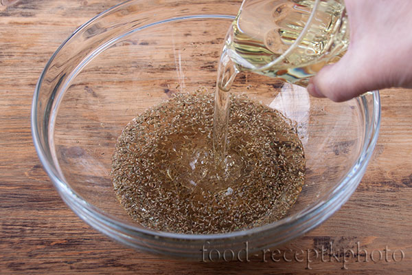 На фото стеклянный салатник с вином и семенами аниса и вливаемое растительное масло