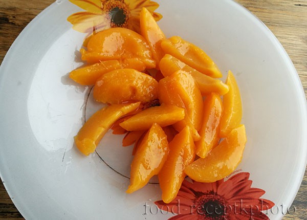На фото консервированные персики  в тарелке