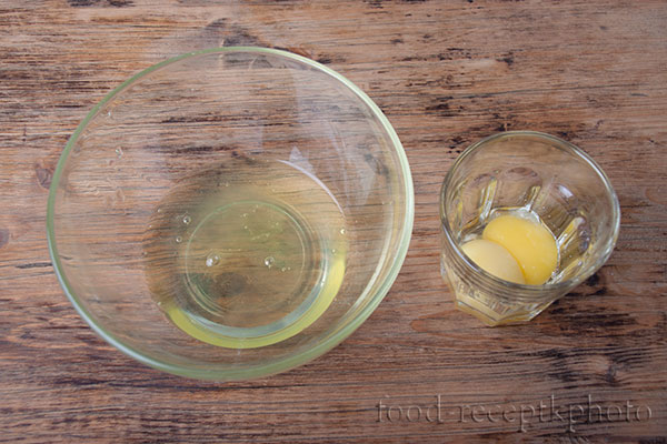 На фото стеклянный салатник с белками от яиц и стакан с желтками