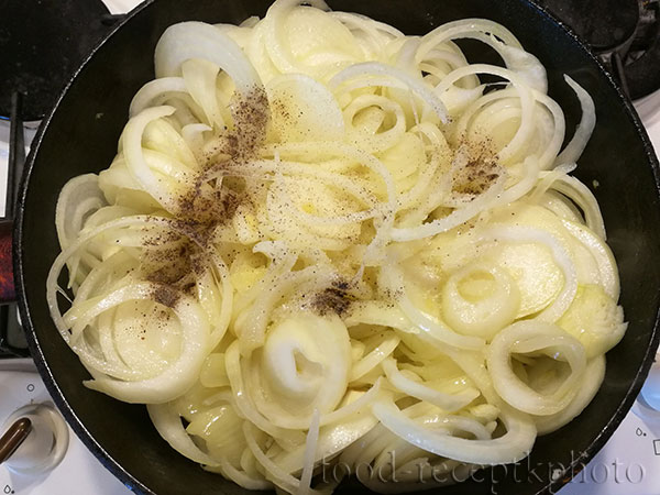 На фото в сковороде нарезанный репчатый лук для начинки в луковый пирог