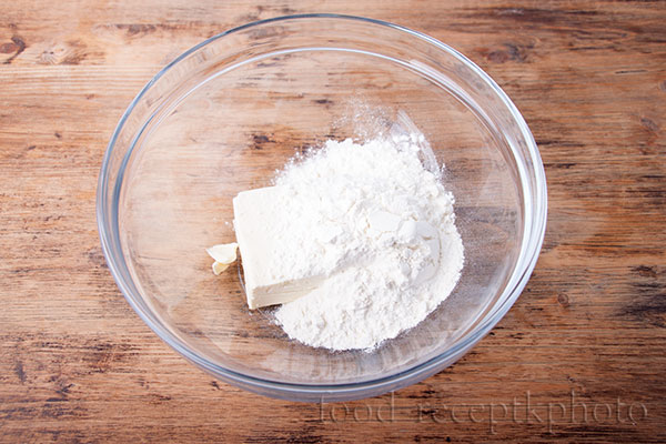 На фото ингредиенты для приготовления теста для лукового пирога в стеклянном салатнике