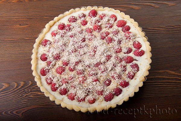 На фото форма для выпечки с песочным тестом и сметанной заливкой с ягодами малины для пирога