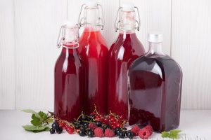 На фото бутылки с соком из ягод заготовки на зиму