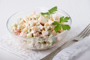 На фото в стеклянном салатнике салат из крабовых палочек с мясом,яйцами,кукурузой и свежими огурцами